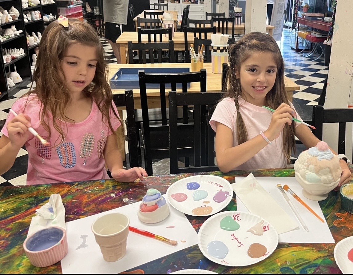 Girls painting pottery