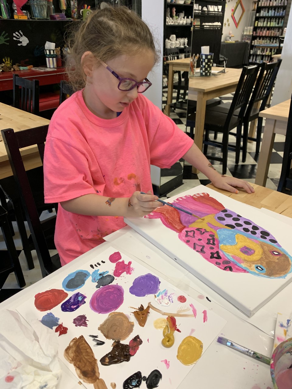 Kid enthusiastically participating in a mosaic art class